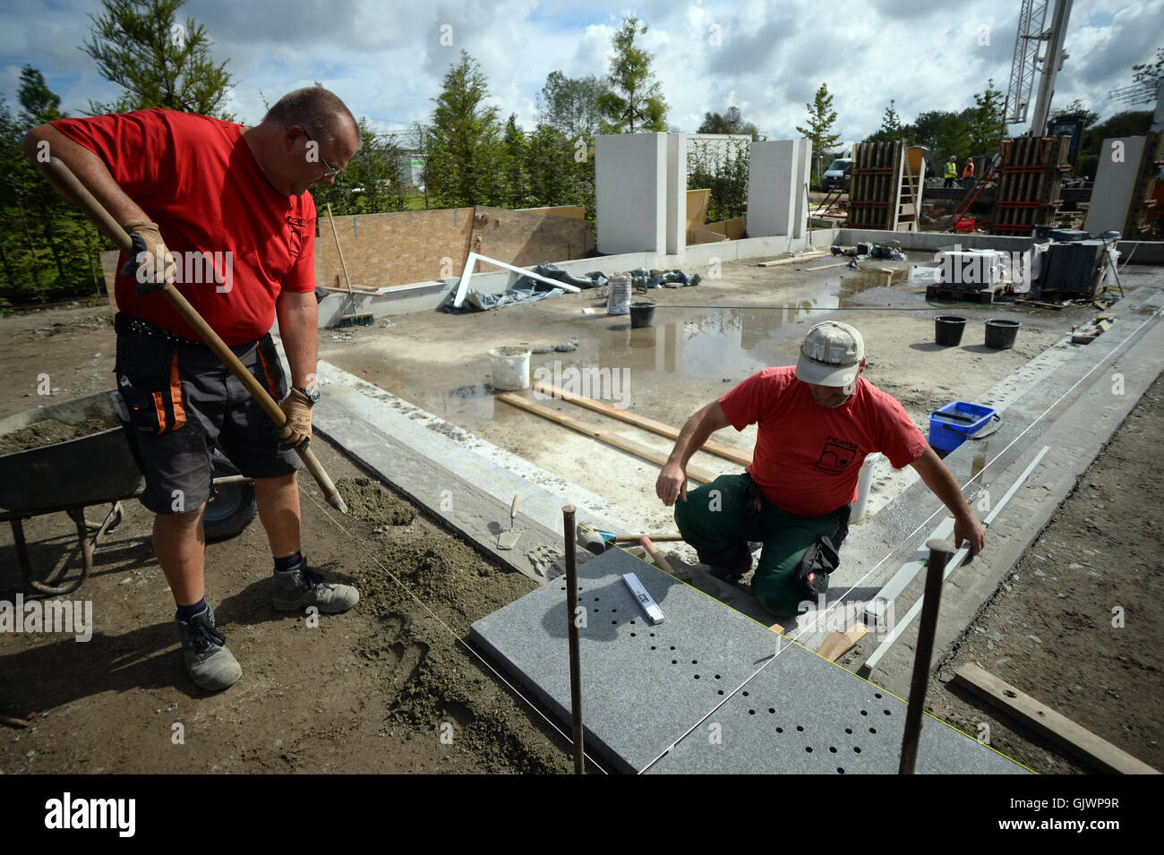 berlin, germany. 17th aug, 2016. workers lay granite tiles at the berlin, germany. 17th aug, 2016. workers lay granite tiles at the