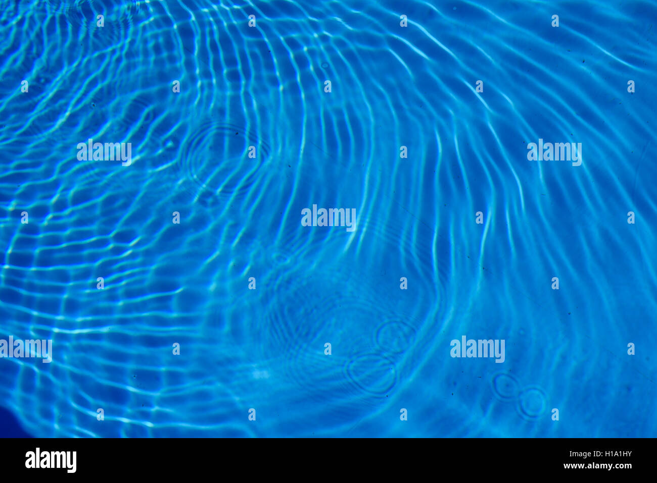 Dark Blue Pool Water blue water ripples of a swimming pool. the water drops cause tiny Dark Blue Pool Water blue water ripples of a swimming pool. the water drops cause tiny