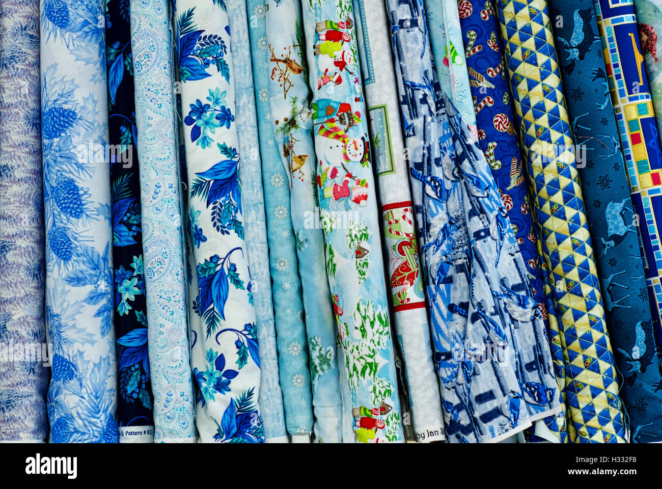 Bolts of colorful fabrics lined up for sale in a variety of styles