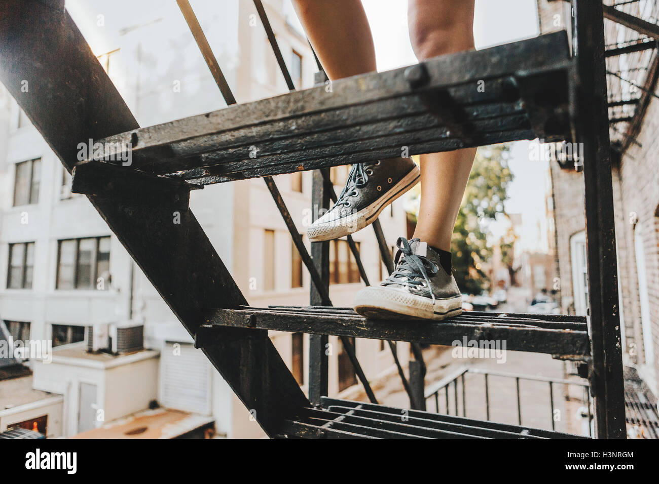 Apartment Building Fire Escape Ladder woman climbing fire escape ladder of apartment building, boston Apartment Building Fire Escape Ladder woman climbing fire escape ladder of apartment building, boston