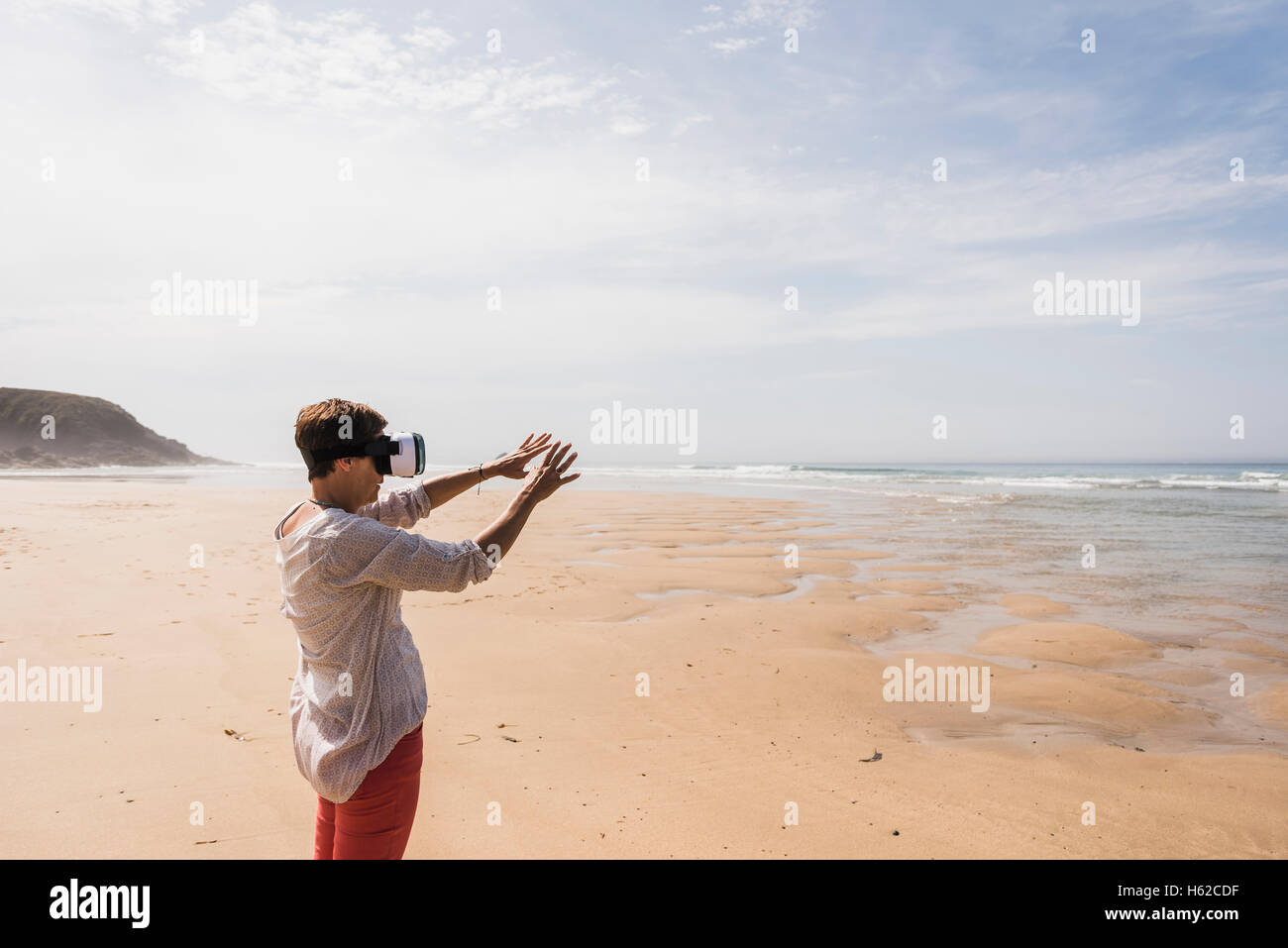 Mature Woman Standing On The Beach Wearing VR Glasses Stock Photo Alamy