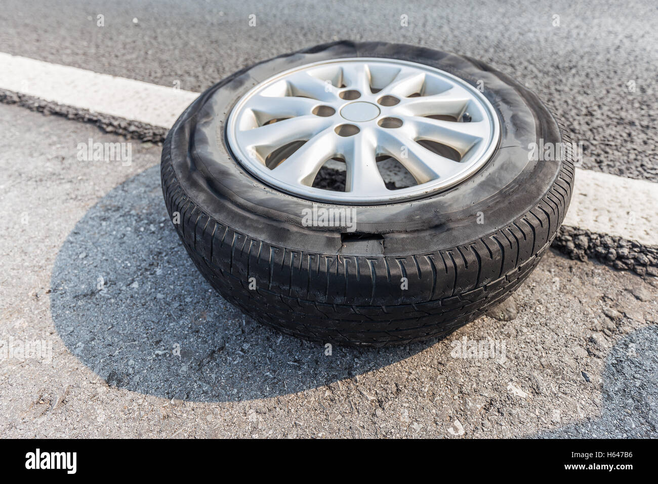 Broken tire damaged on tire surface putting on edge of road Stock Photo