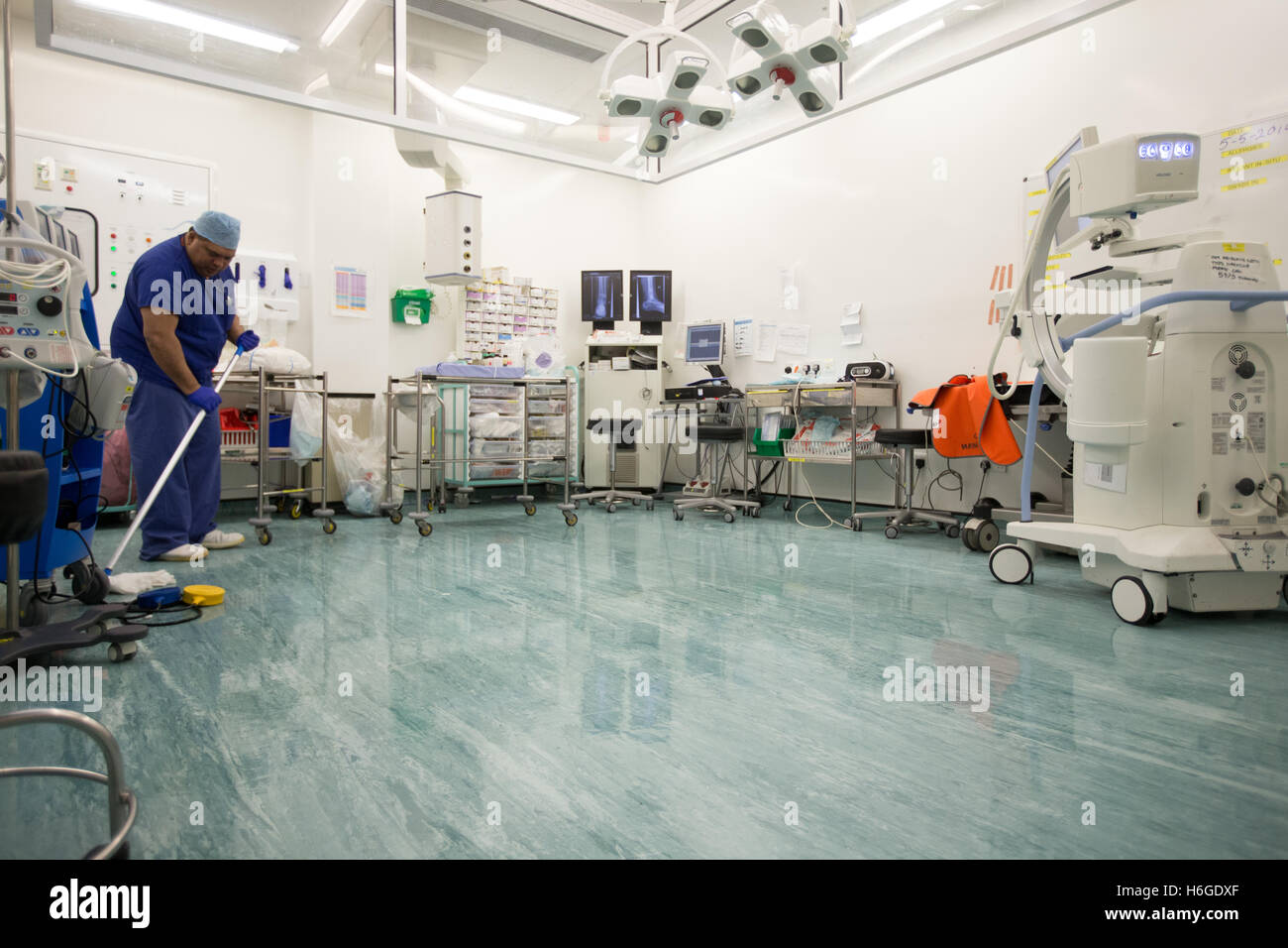 A Technician Cleans An Operating Theatre In An NHS Hospital Stock Photo a-technician-cleans-an-operating-theatre-in-an-nhs-hospital-stock-photo