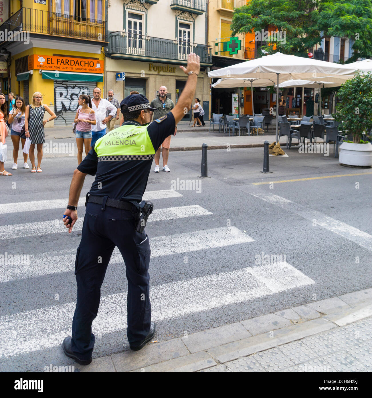 A Spanish police officer directing traffic on a pedestrian crossing