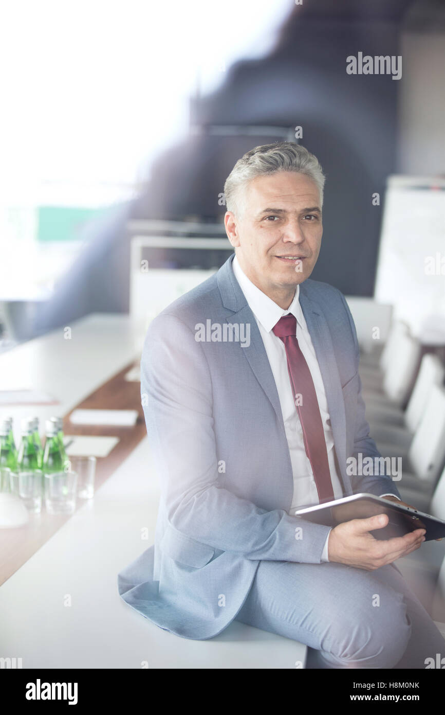 Portrait Of Confident Mature Businessman Holding Digital Tablet While