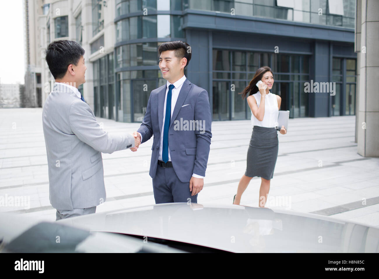 Confident Chinese Business People Shaking Hands Outdoors Stock Photo