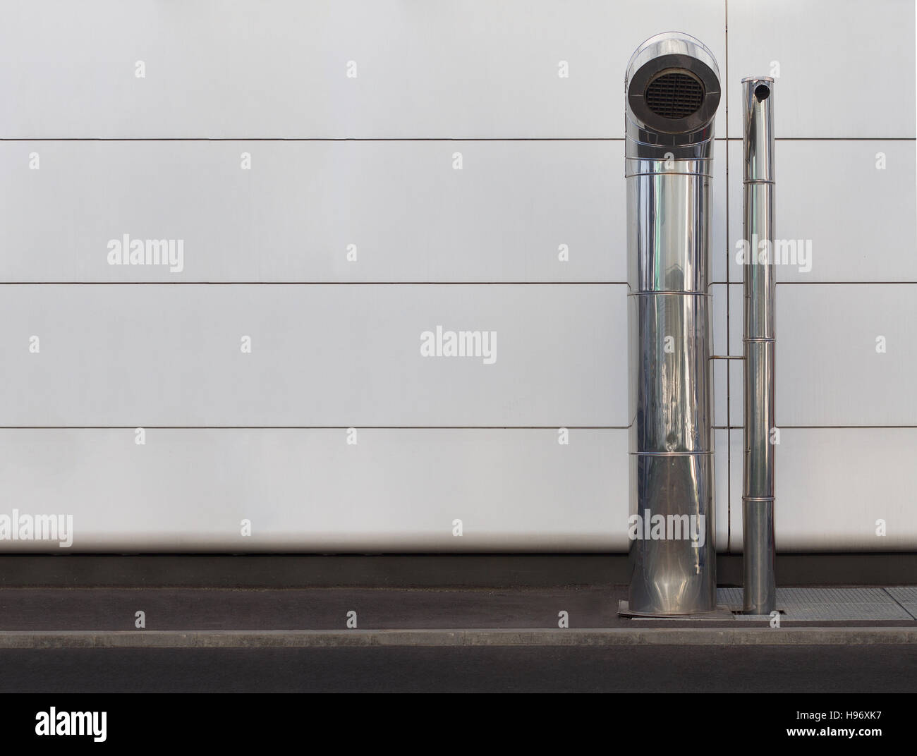 Front view of two chrome industrial vents on street sidewalk with Stock