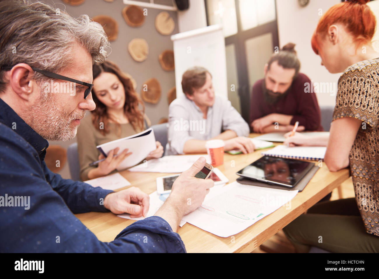 Mature Man Using Smartphone During The Business Meeting Stock Photo Alamy