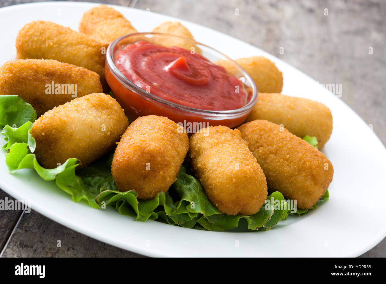 Traditional fried Spanish croquetas (croquettes) with ketchup in Stock