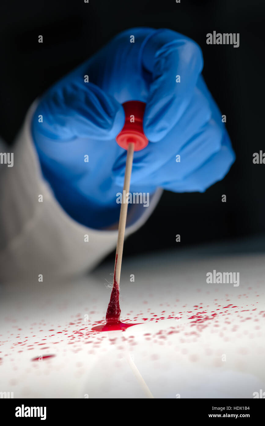 Forensic Technician Taking DNA Sample From Blood Stain With Cotton Swab