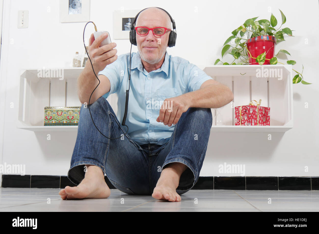 Handsome Mature Man Listening To Music With Headphones At Home Stock