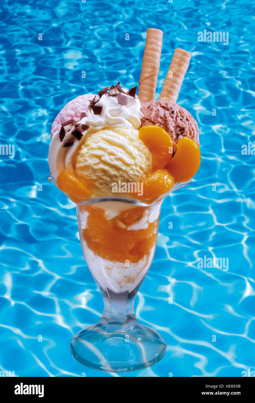 Mixed ice cream sundae with fruit standing in a swimming pool Stock