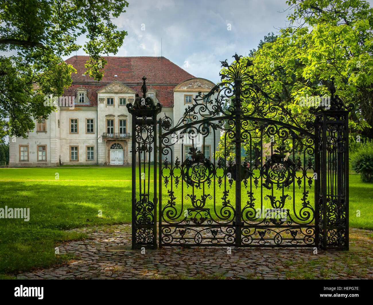 Locked iron gate in front of an abandoned Baroque manor house Stock
