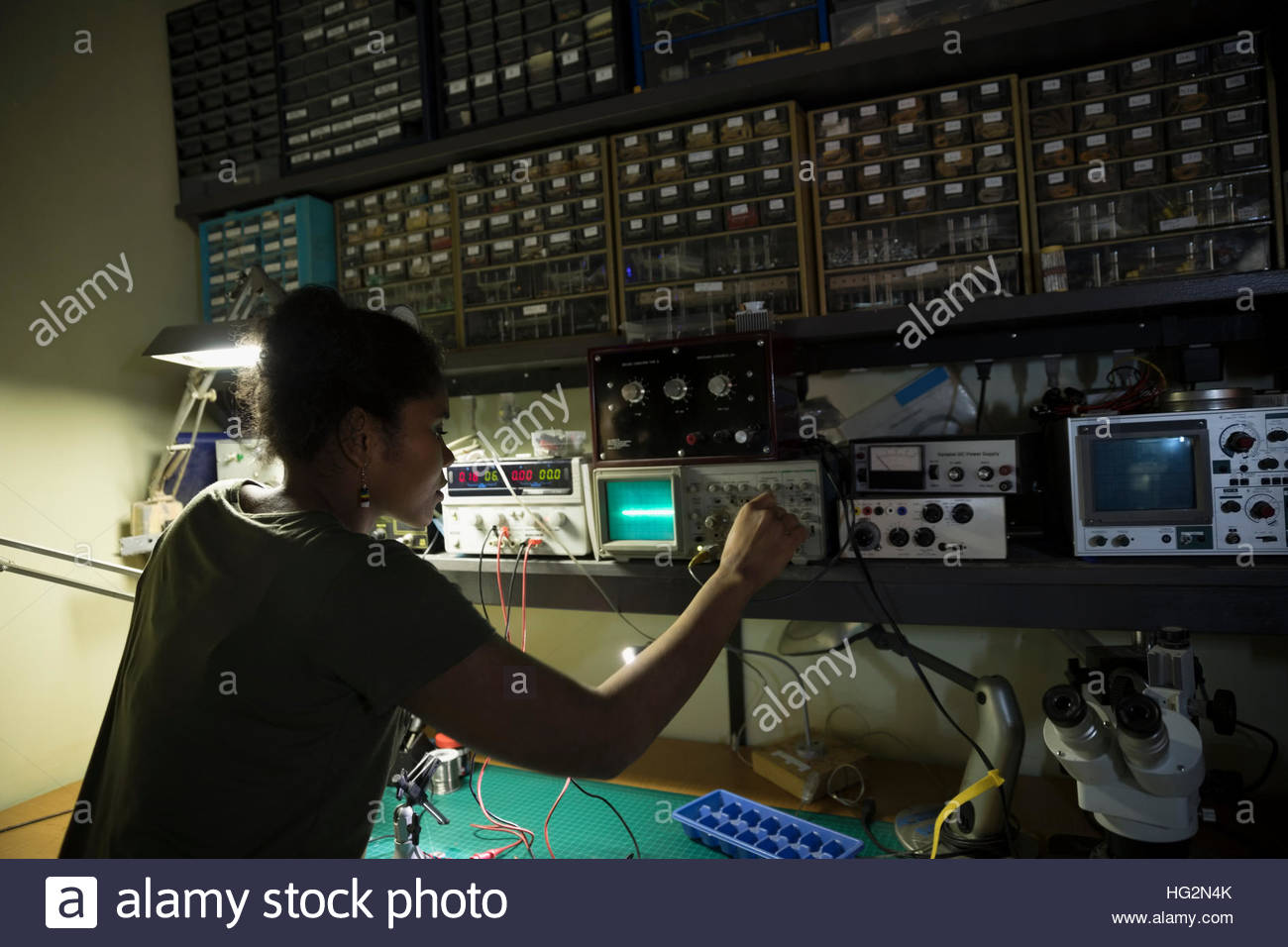 Female Engineer Working On Electronics Equipment In Workshop Stock