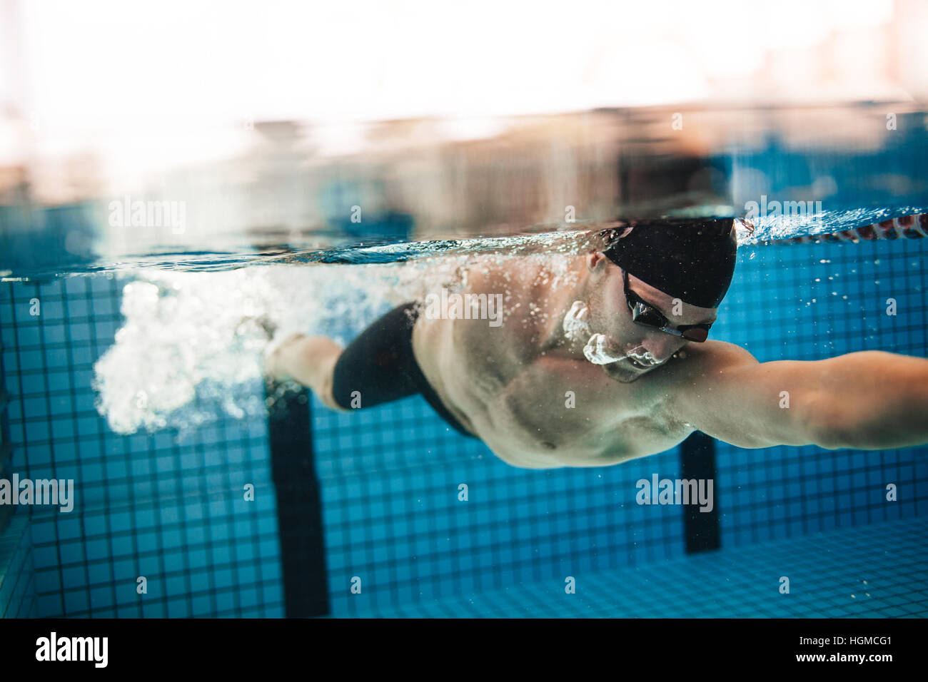 underwater shot of pro male swimmer in action inside swimming pool young sportsman training in the pool - Inside Swimming Pool underwater shot of pro male swimmer in action inside swimming pool young sportsman training in the pool - Inside Swimming Pool