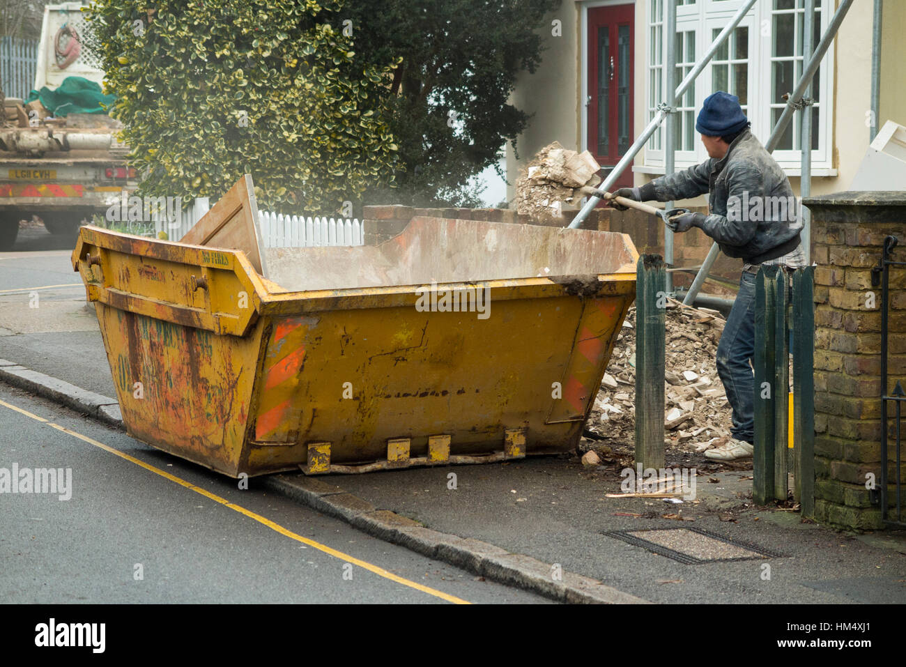 Builders waste rubbish skip, on pavement & yellow, line being filled