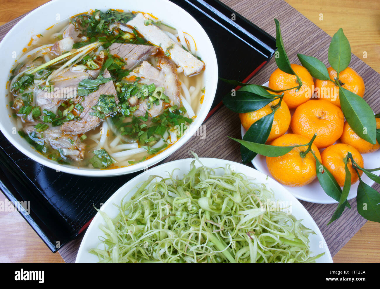 Stock Photo - Bun bo Hue is popular Vietnamese soup contain rice vermicelli (bun) and beef, this is delicious street food or meal, salty noodle bowl with vegetables