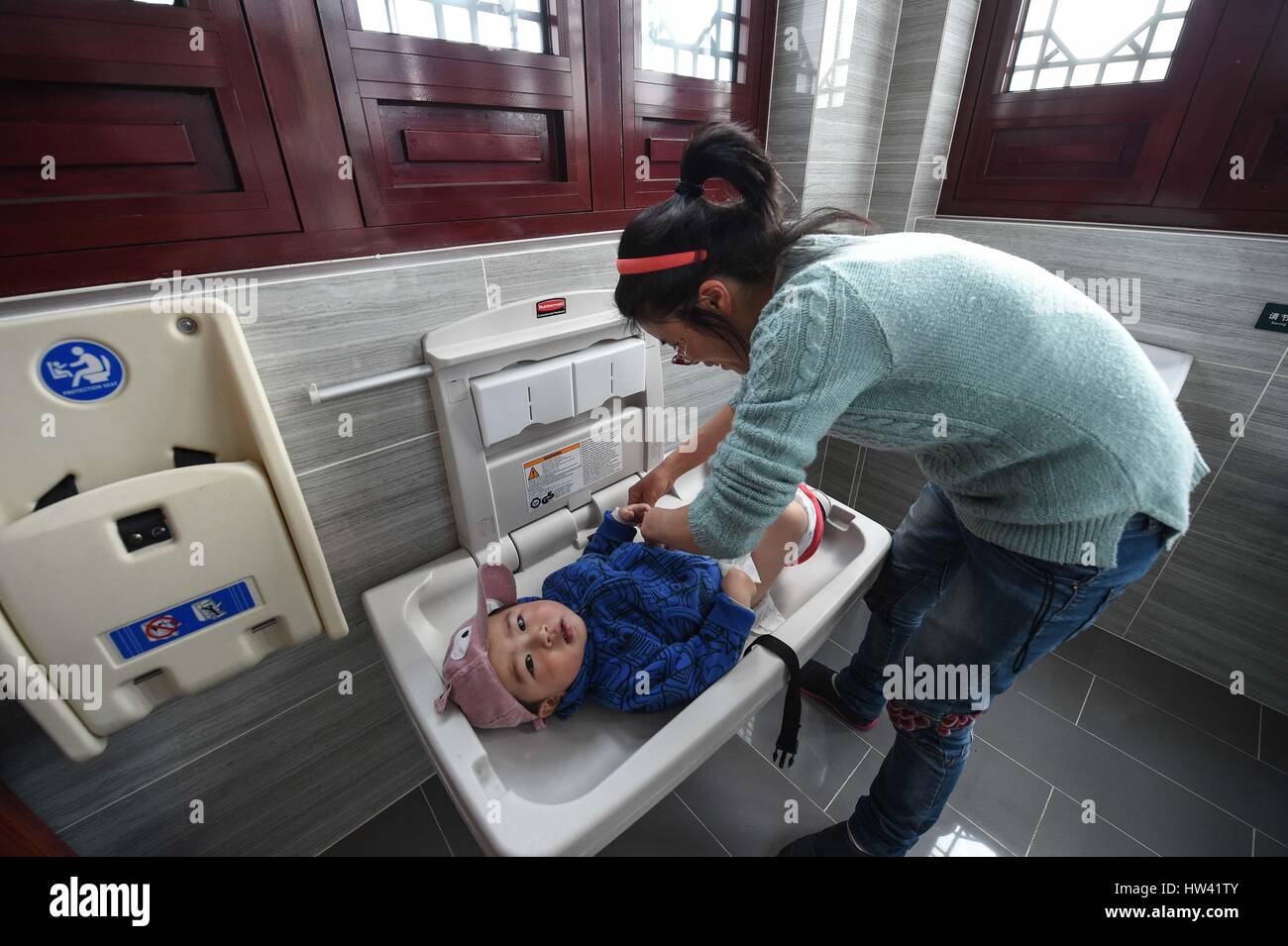 Suzhou, China's Jiangsu Province. 15th Mar, 2017. A woman changes Stock
