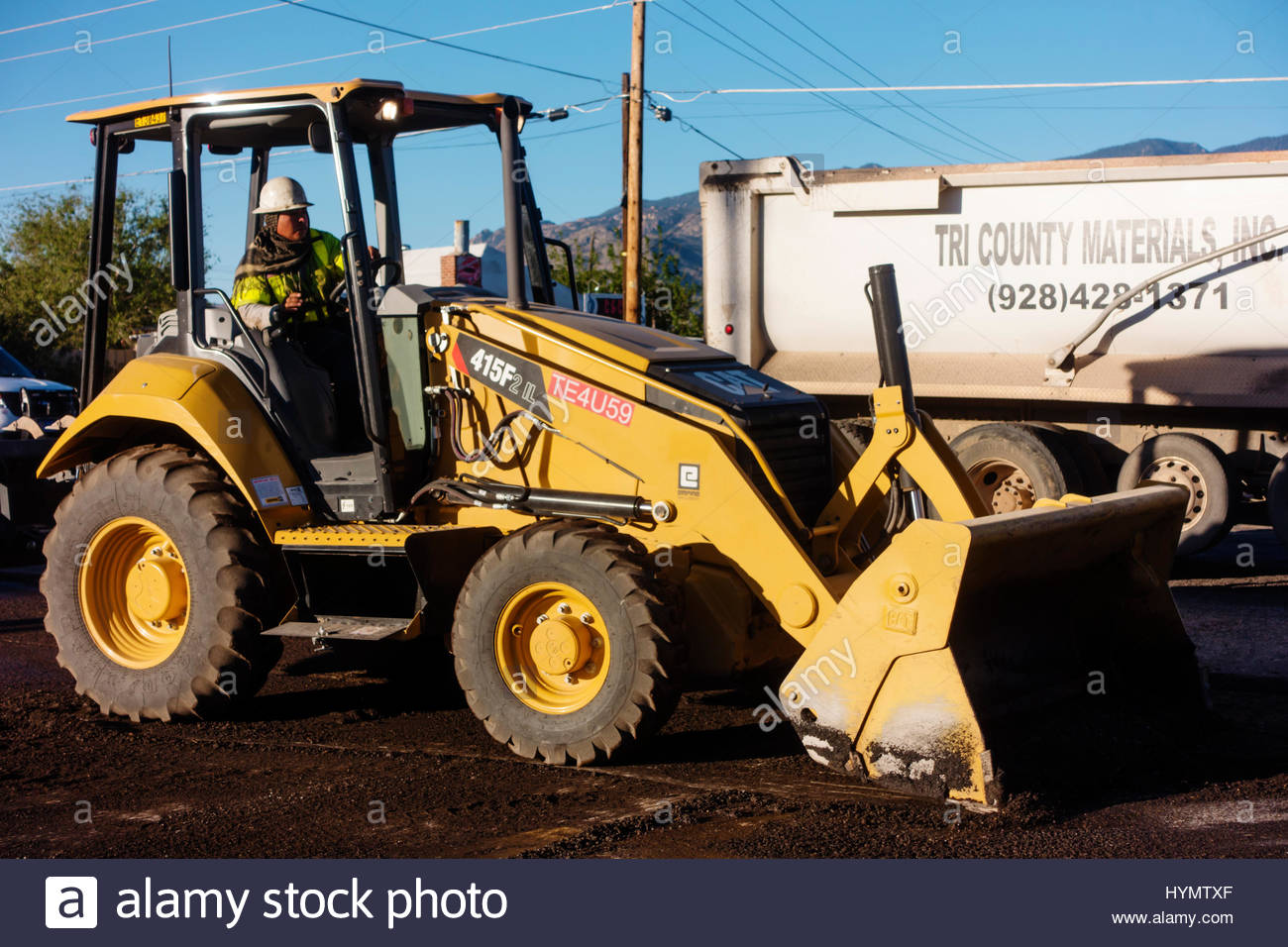 Caterpillar 415F2 loader working on road construction in Arizona operator visible Stock Photo