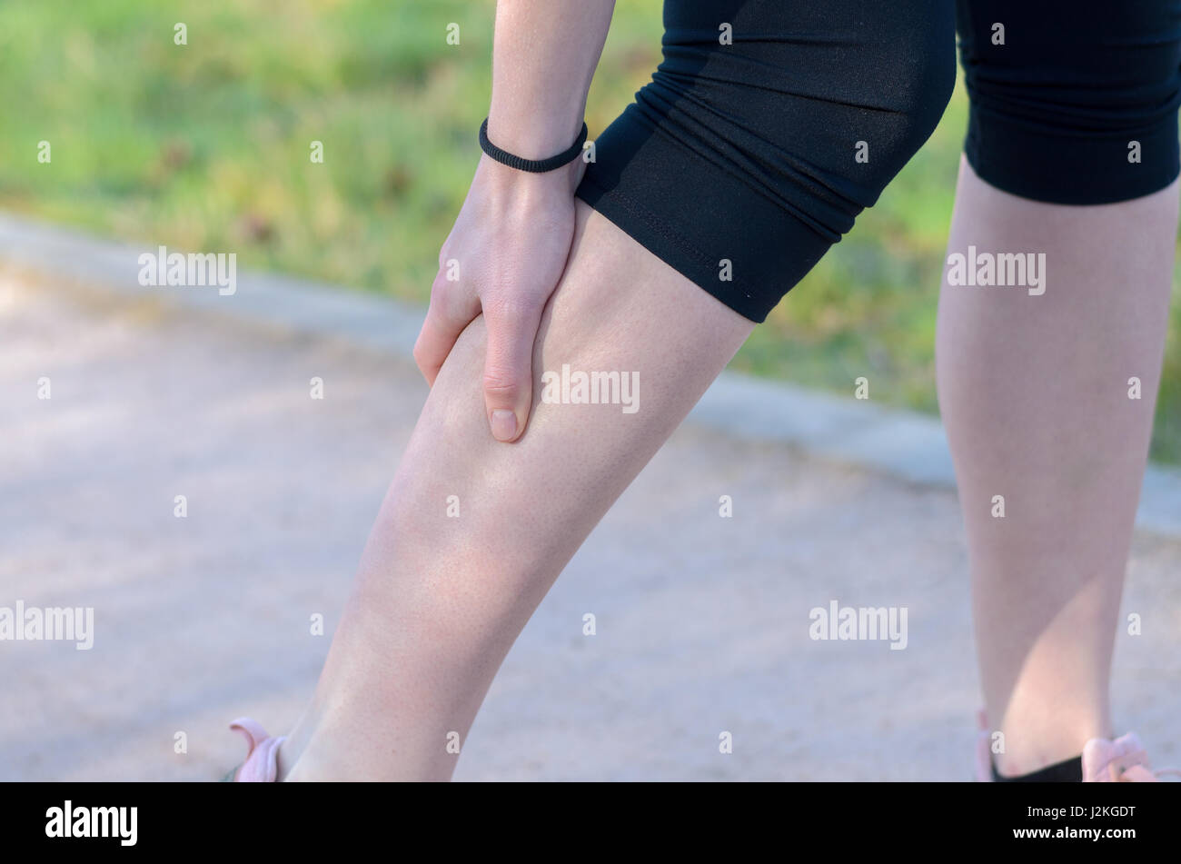 Young woman jogger suffering from calf muscle spasm or cramps ... Young woman jogger suffering from calf muscle spasm or cramps ...