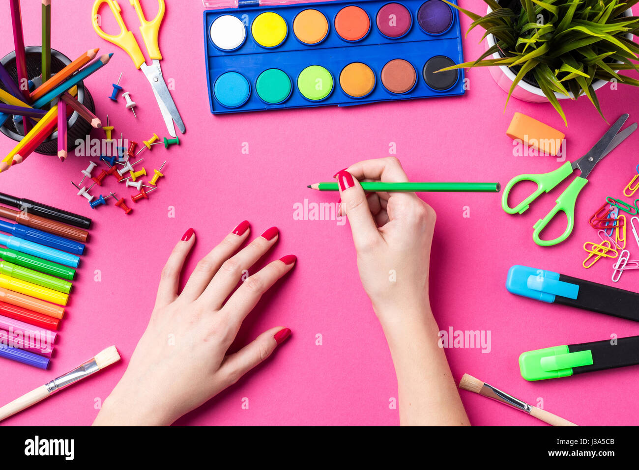 Womans Hand Drawing On Pink Paper School Or Art Supplies On Pink Womans Hand Drawing On Pink Paper School Or Art Supplies On Pink