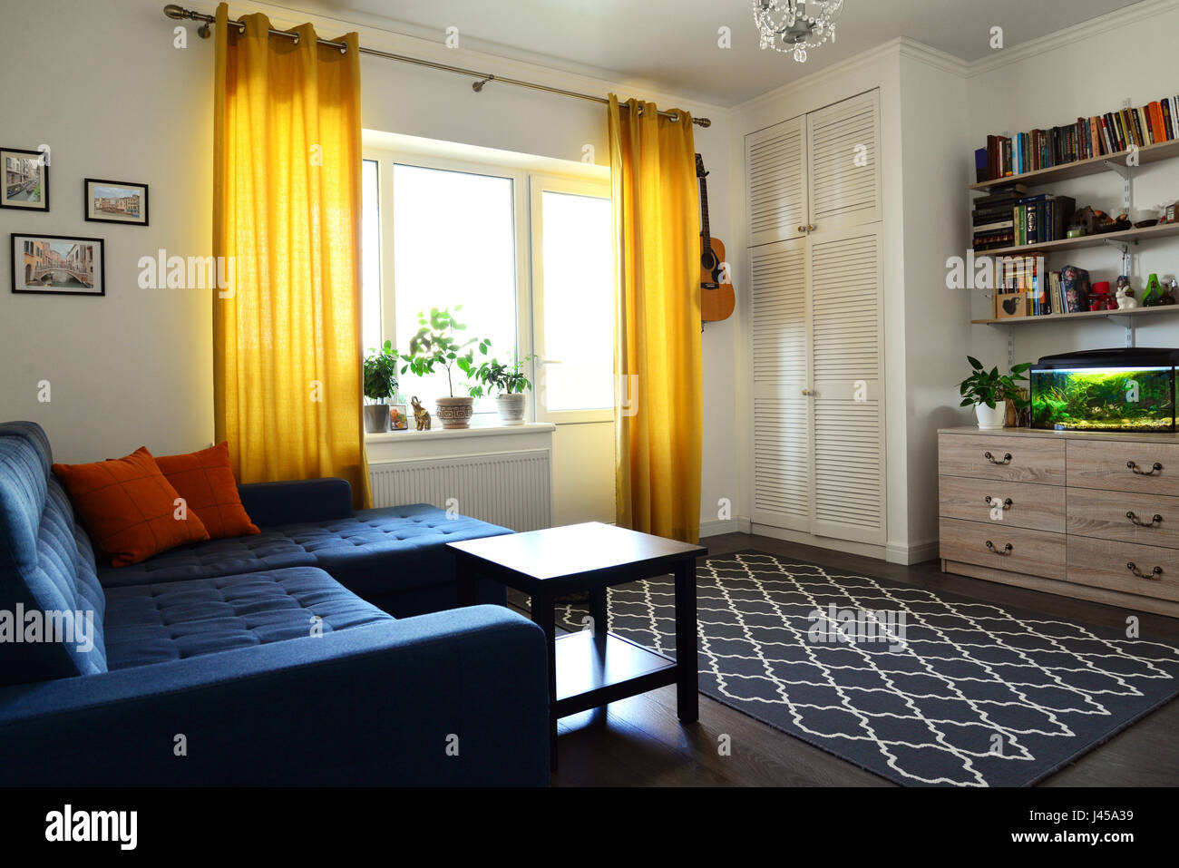 Clean family room with blue couch, white brick wall and yellow ... Clean family room with blue couch, white brick wall and yellow ...