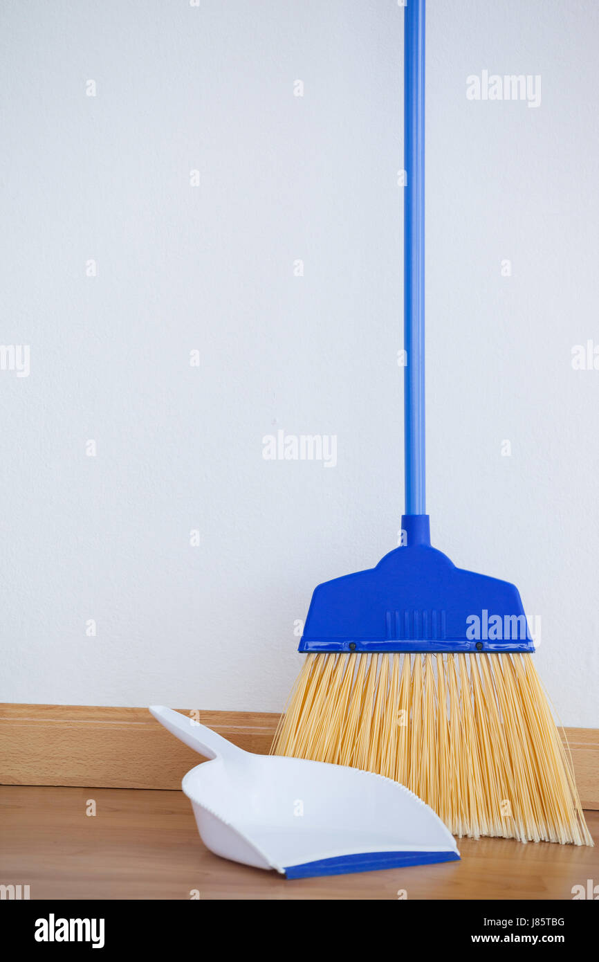 close-up of dustpan and sweeping broom on wooden floor stock photo close-up of dustpan and sweeping broom on wooden floor stock photo