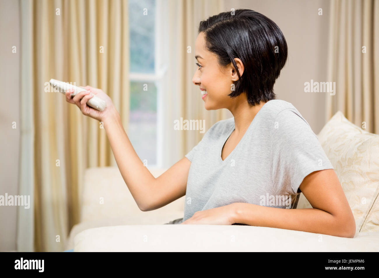Smiling Brunette Using Remote Stock Photo Alamy