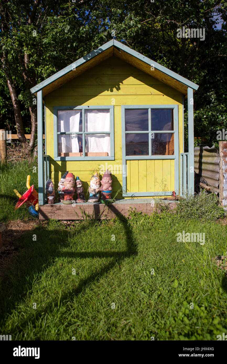 a small painted wood house for children to play in with gnome a small painted wood house for children to play in with gnome