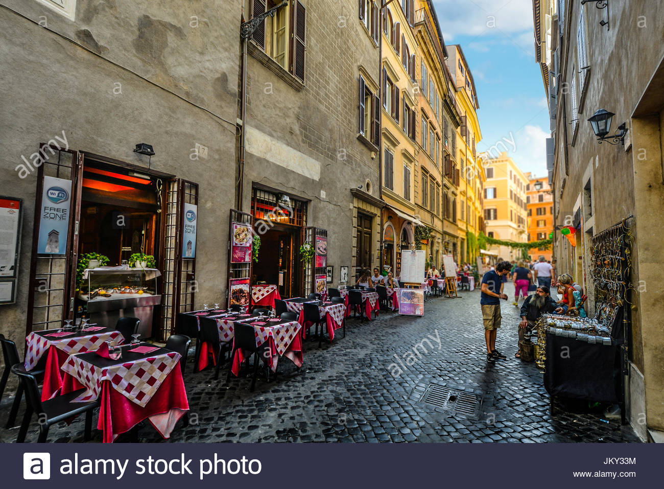 Colorful restaurant with sidewalk cafe in a back alley in Rome Italy