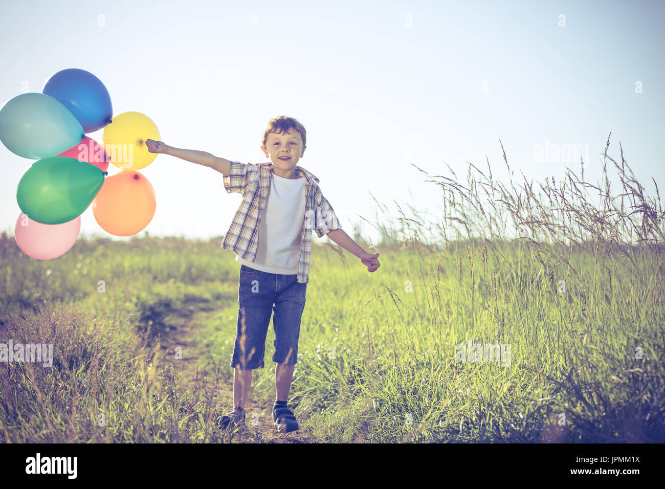 Happy Little Boy On Road At The Day Time He Running In The Field And Holding In Hands Balloons Kid Having Fun On The Nature Concept Of Hap Happy Little Boy On Road At The Day Time He Running In The Field And Holding In Hands Balloons Kid Having Fun On The Nature Concept Of Hap