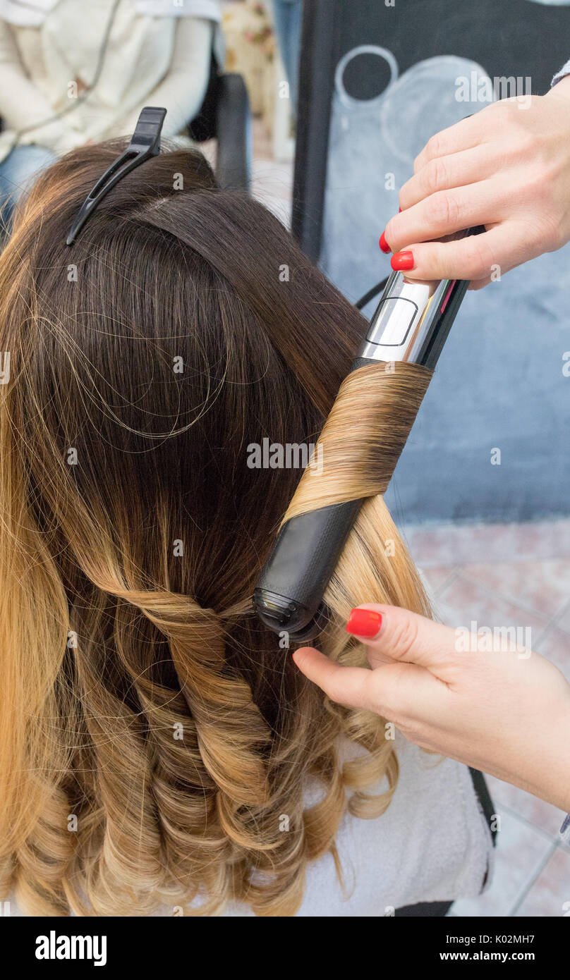 Professional Hairdresser Curling Ombre Hair With Iron In Beauty