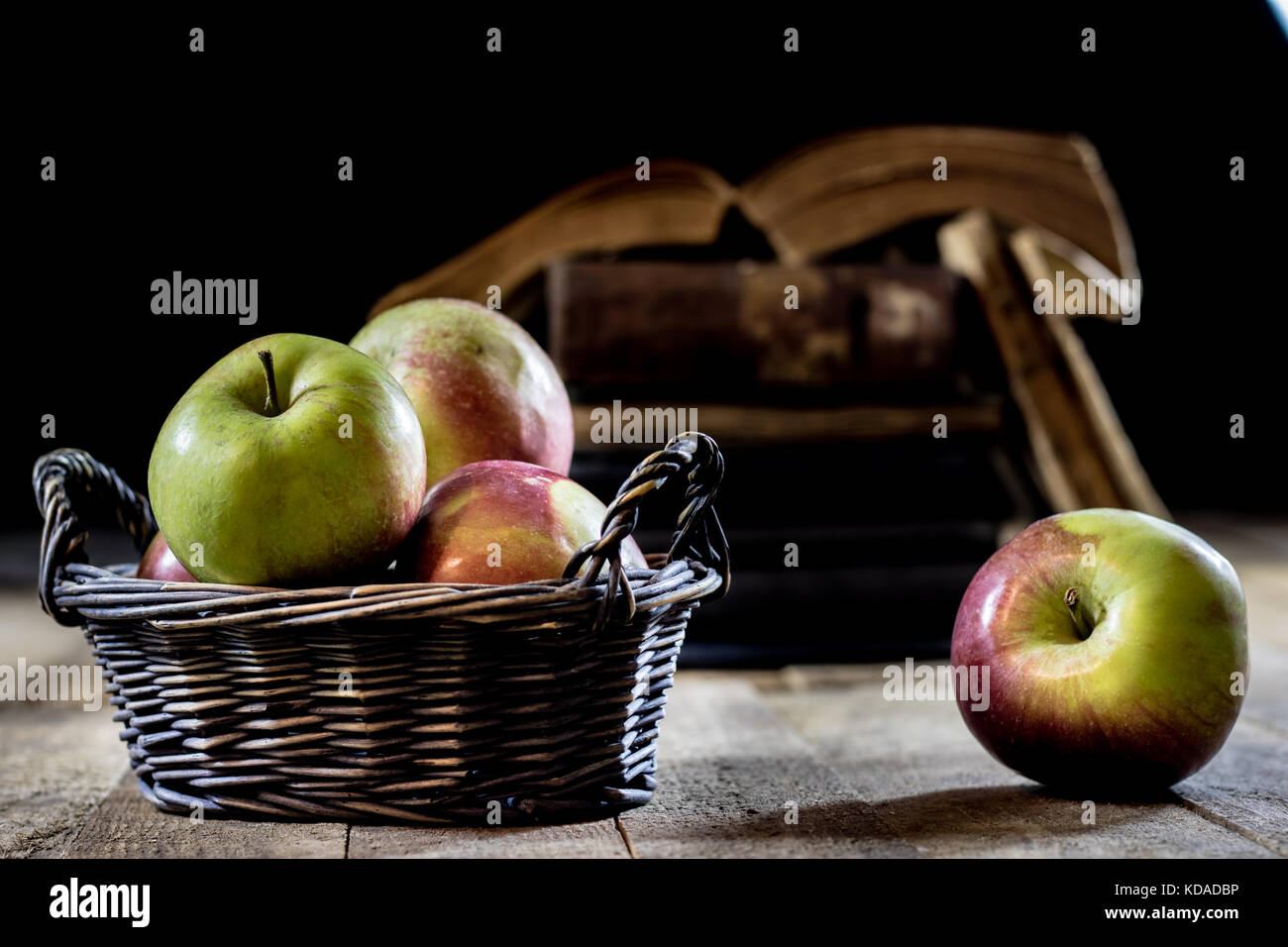 Tasty Apples In Basket On Kitchen Table Old Books Lie Next To