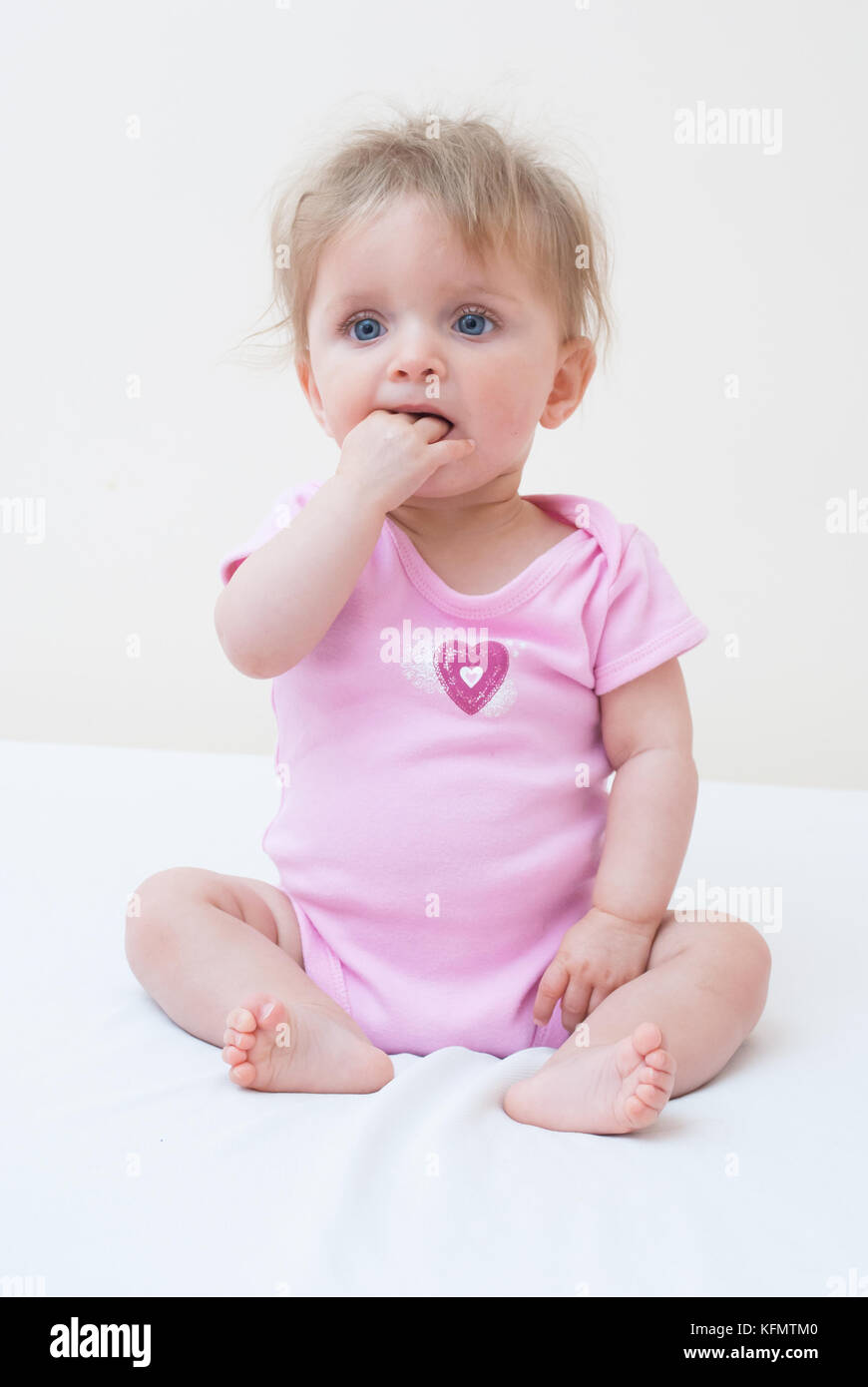 Adorable Cute Baby Teething With Her Fingers In Her Mouth Stock Photo