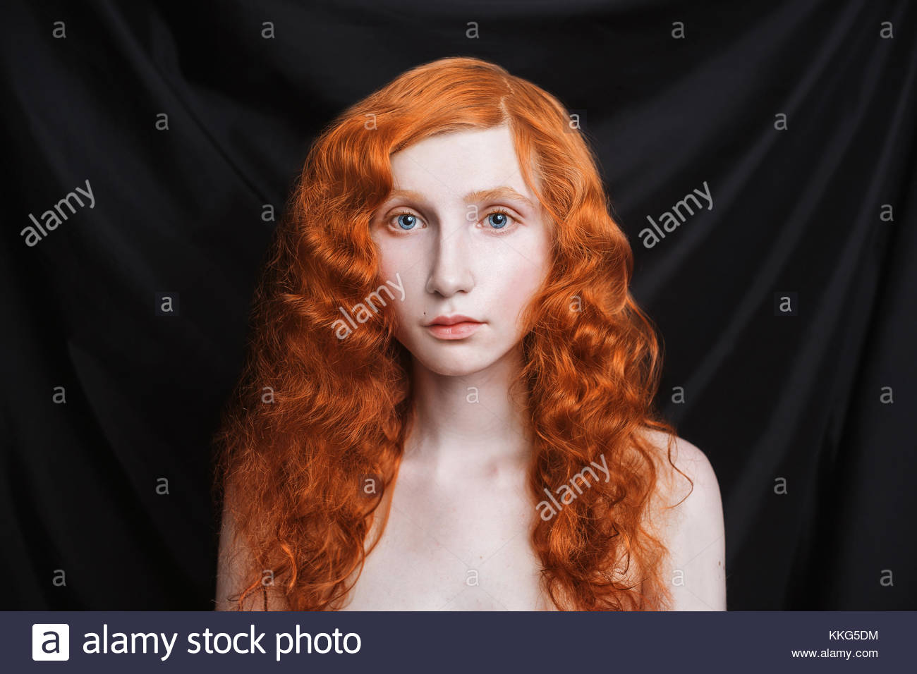 Woman With Long Curly Red Flowing Hair On A Black Background Stock