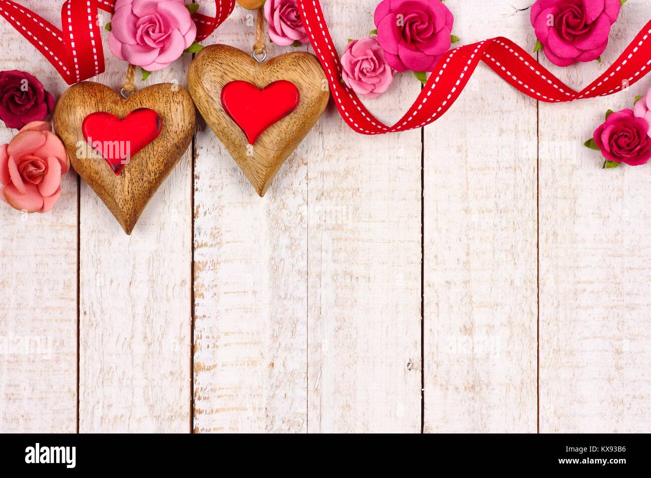 Two Valentines Day Wood Hearts With Roses And Ribbon Top Border Against A Rustic White Background Copy Space Two Valentines Day Wood Hearts With Roses And Ribbon Top Border Against A Rustic White Background Copy Space