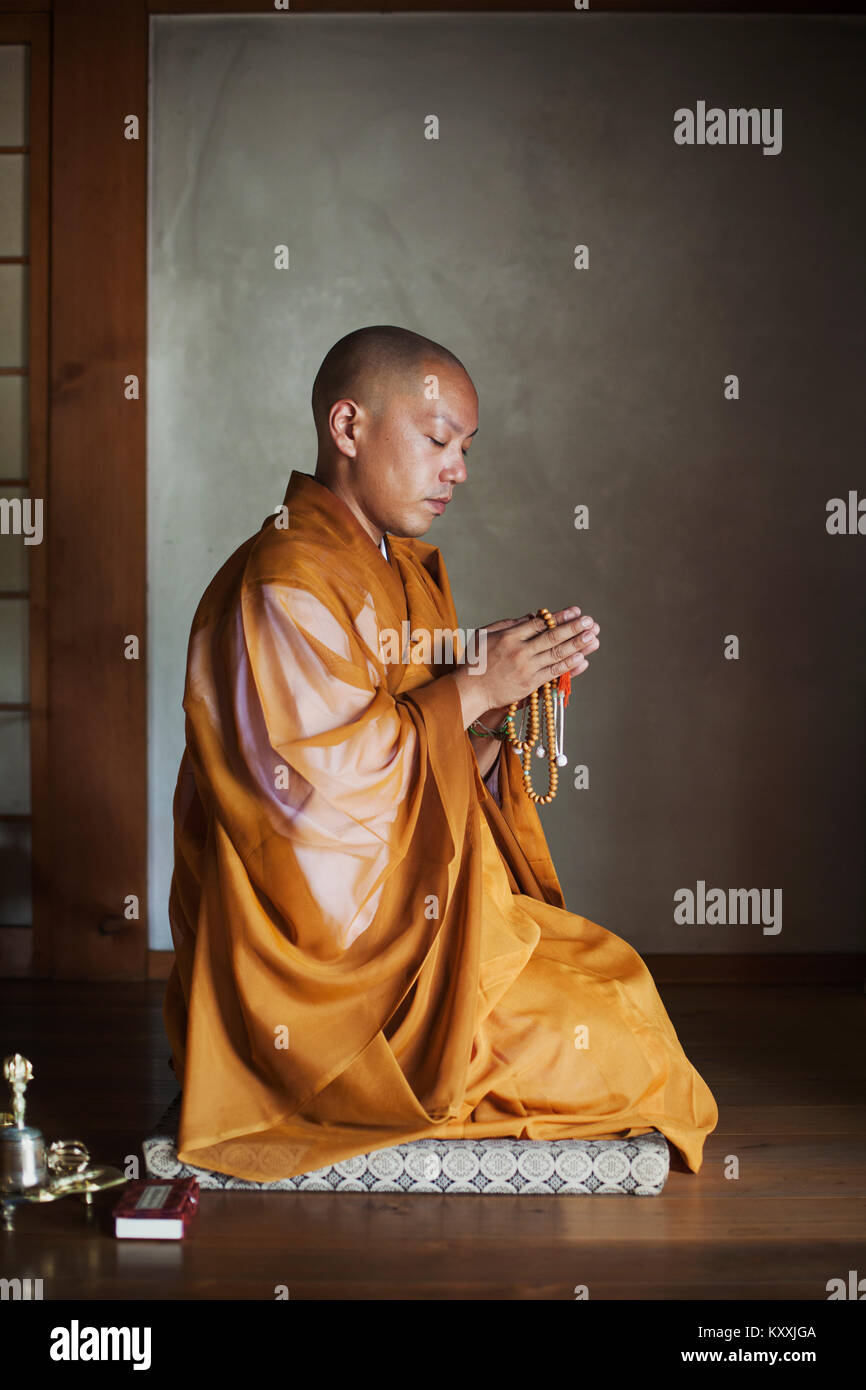 Side View Of Buddhist Monk With Shaved Head Wearing Golden Robe