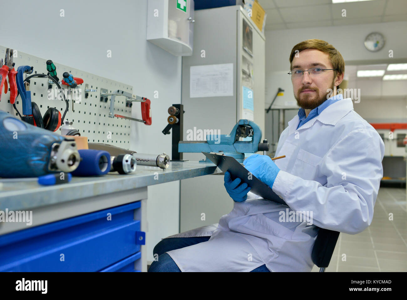 portrait of young medical engineer posing in laboratory sitting by orthopedic technologist