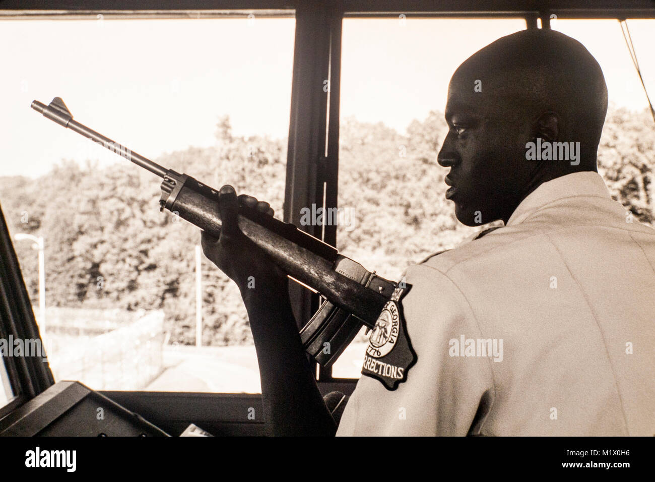 a-tower-guard-holds-his-sniper-rifle-inside-a-state-prison-in-georgia-M1X0H6.jpg