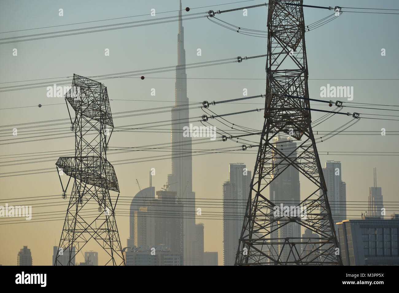 DUBAI, UAE - FEBRUARY 11, 2018. A view of Burg Khalifa and Dubaicenter seen trough the electric wires network alongside of a motorway near Dubai.