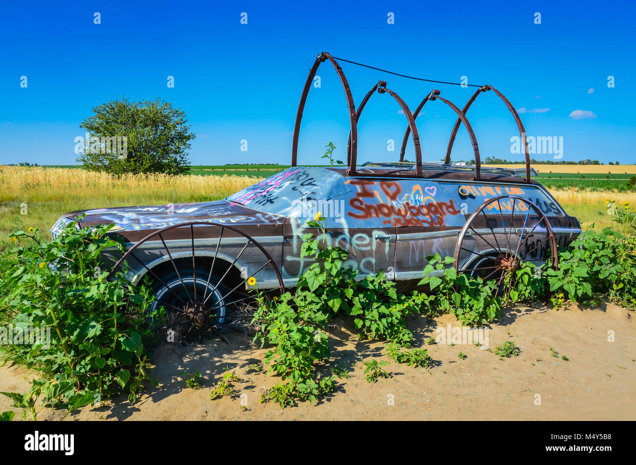 Solo Station Wagon Covered In Wagon Wheels Forms Trellis For Plants