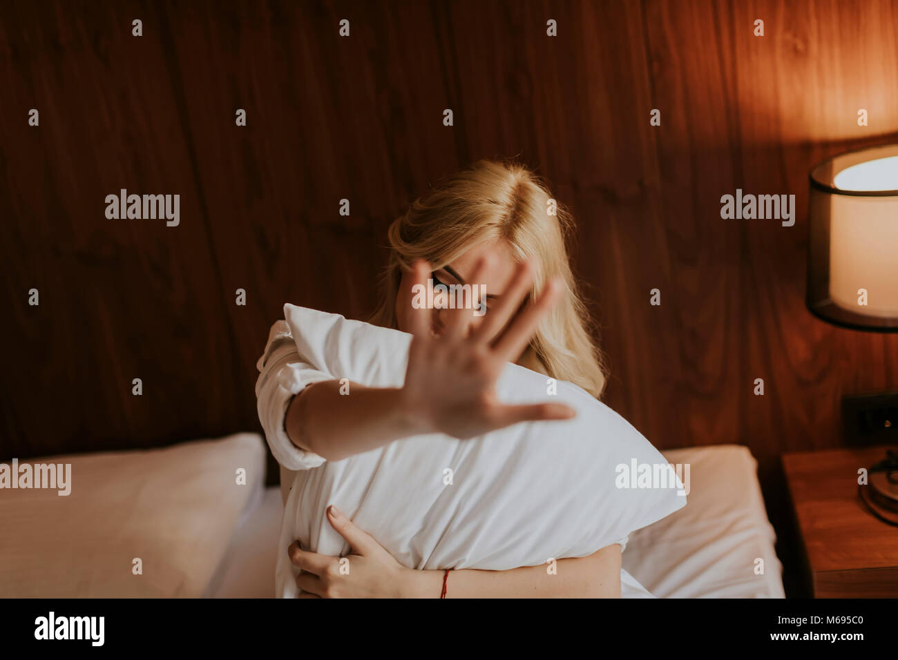 Portrait Of Happy Blonde Woman Hugging Her Pillow At Home In The