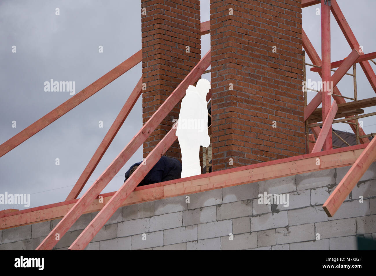 a construction crew works on the roof against a blue sky with a cast crew works
