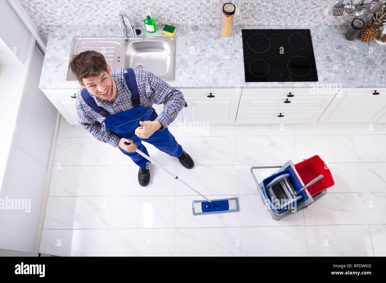 High Angle View Of Janitor Cleaning Floor With Mop In Kitchen Stock