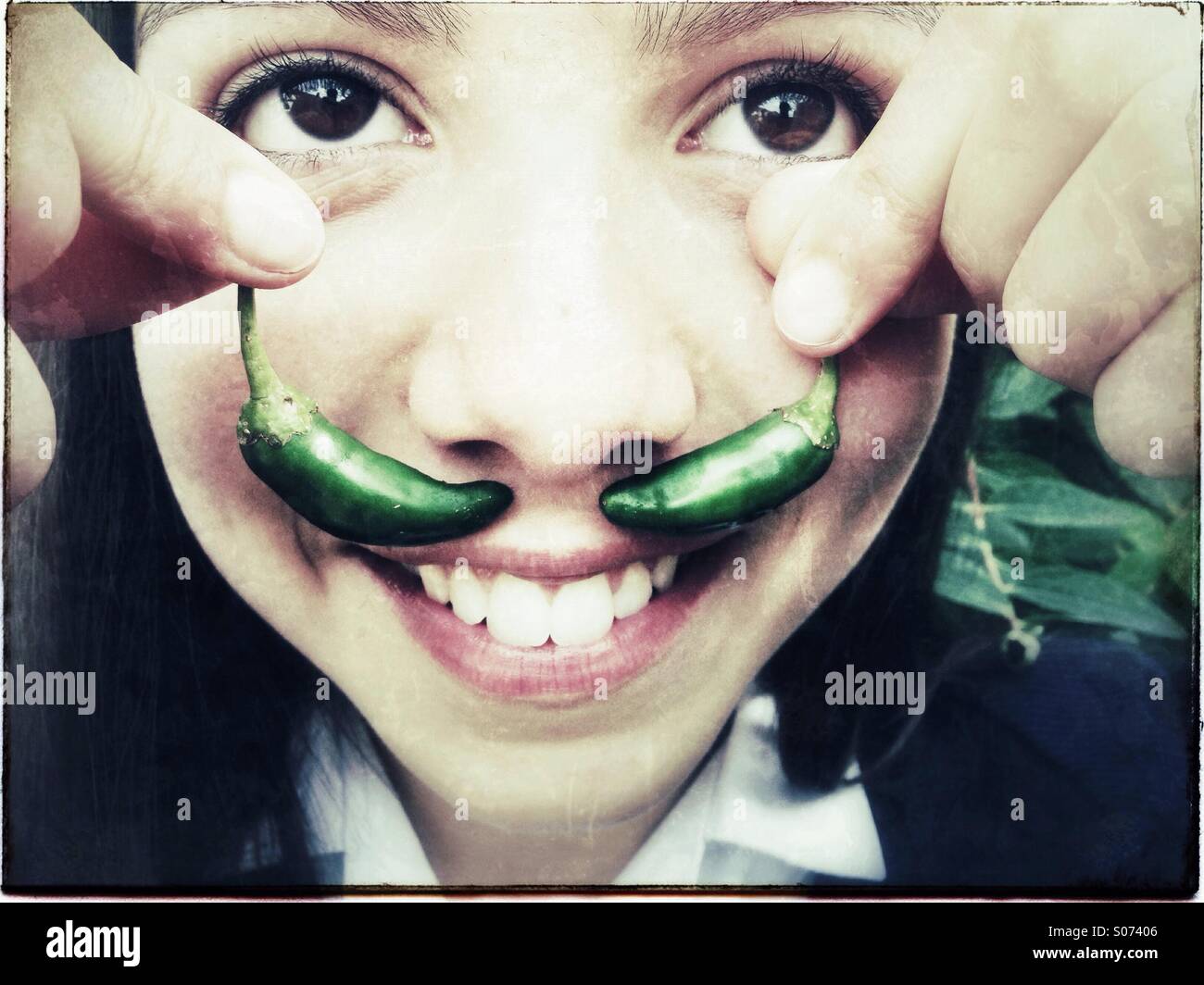 Happy_girl_holds_green_chilies_as_fake_m