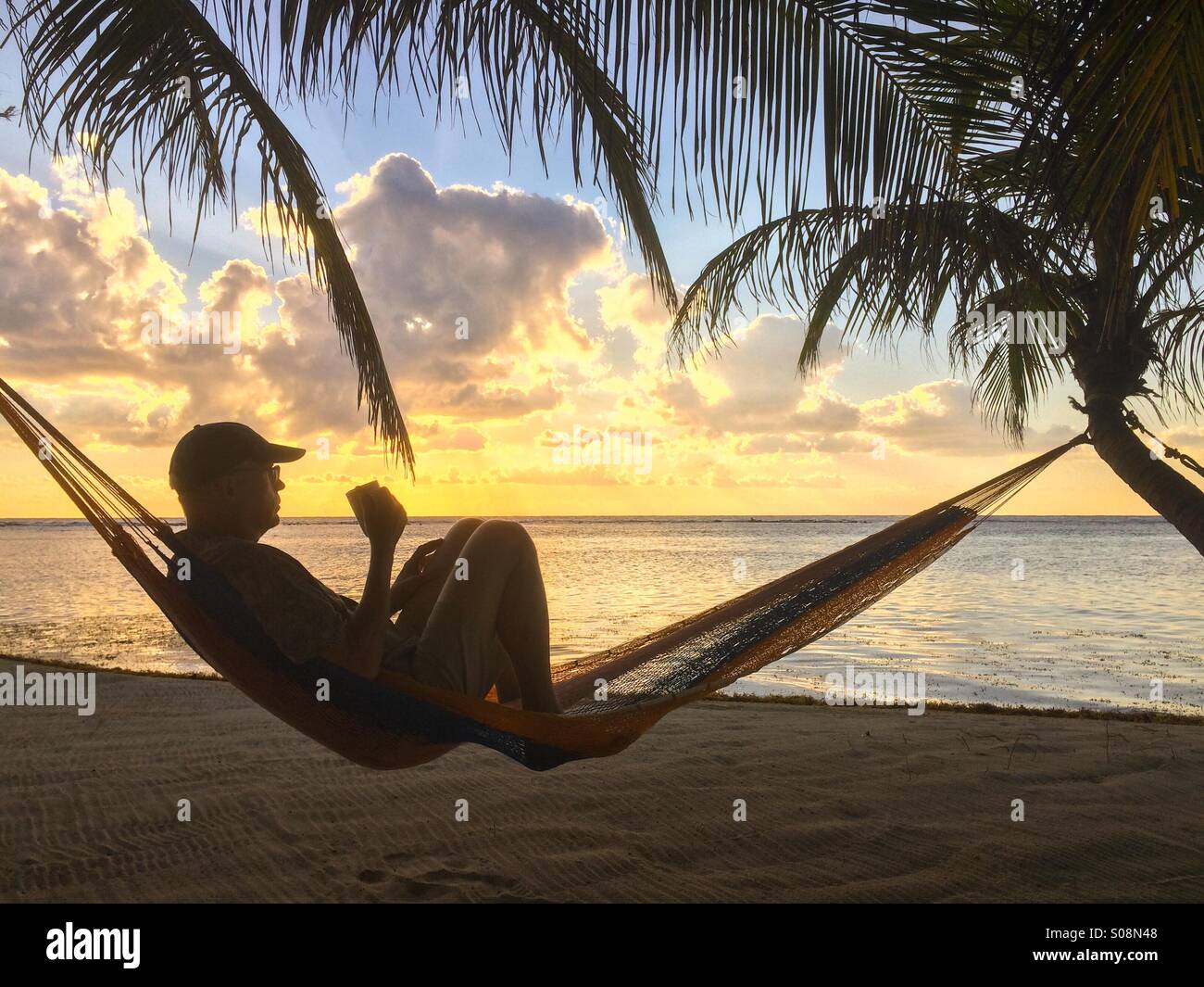 man-drinking-coffee-at-the-beach-in-hammock-caribbean-sea-belize-S08N48.jpg
