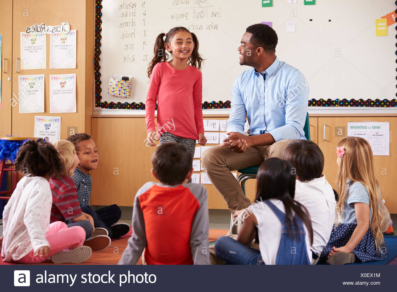 Schoolgirl At The Front Of Elementary Class With Teacher Schoolgirl At The Front Of Elementary Class With Teacher