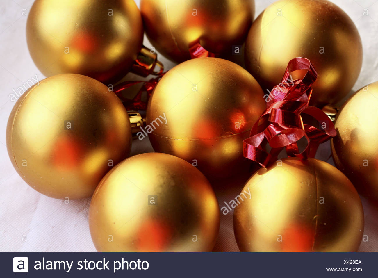 gold christmas balls with red ribbon on white linen gold balls reflect the highlights of red ribbon - Red And Gold Christmas Ornaments gold christmas balls with red ribbon on white linen gold balls reflect the highlights of red ribbon - Red And Gold Christmas Ornaments