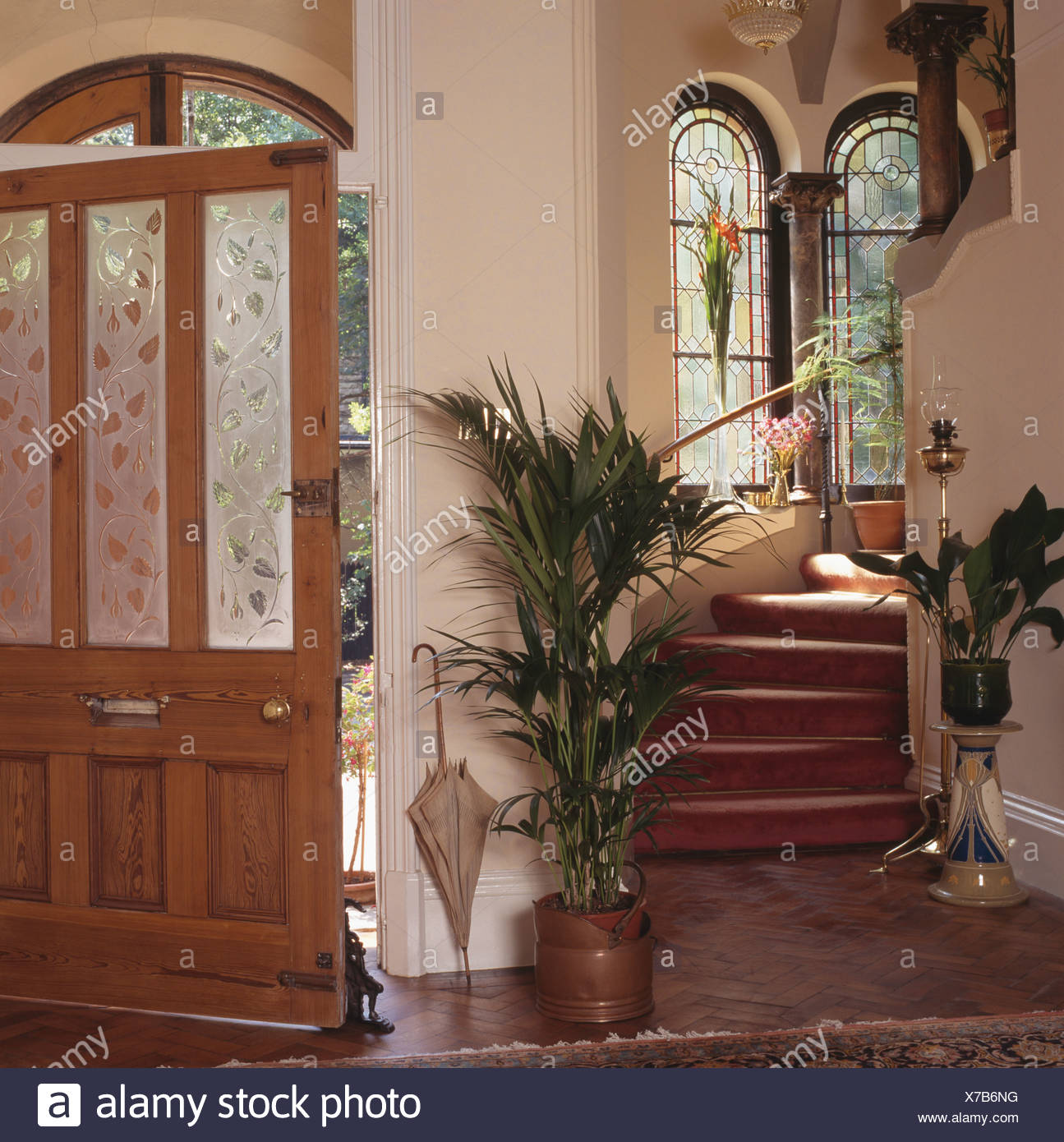Green Houseplants On Either Side Of Staircase In Cream Hall With Green Houseplants On Either Side Of Staircase In Cream Hall With Open Front Door Engraved Glass Panels