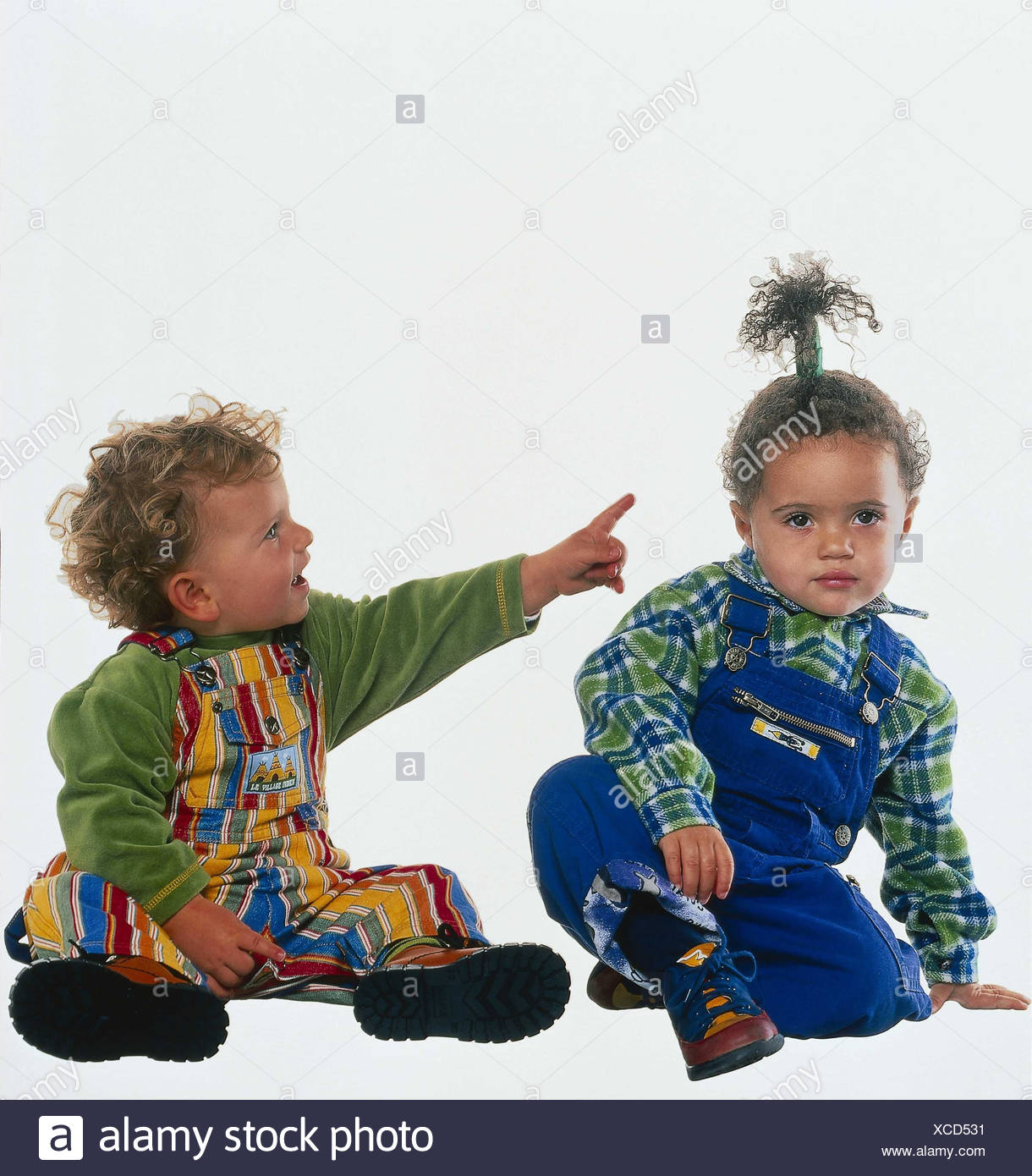infants boy girl overalls sit show floor gesture interpret